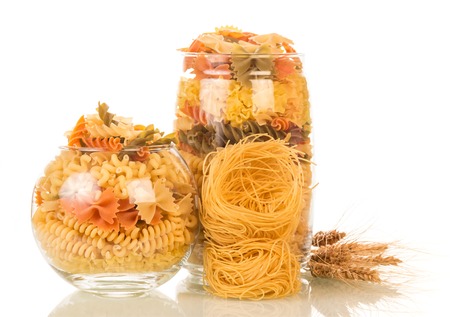 Jars with colored pasta isolated on white background.の写真素材
