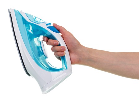 Steam iron in a female hand isolated on white background.の写真素材