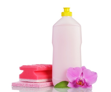 Pink plastic bottle with cleaner, household sponge and orchid flower isolated on white background.の写真素材