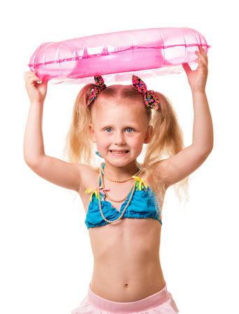 Little blond girl in a swimsuit holding an inflatable ring on the head isolated on white background.の写真素材