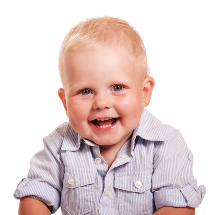 Portrait of a cheerful little boy in a bright striped shirt isolated on white background.の写真素材