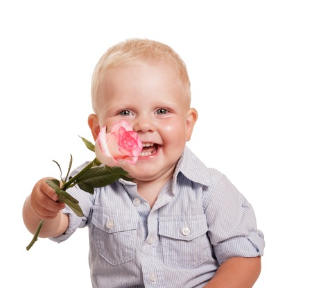 Portrait of a happy boy in bright striped shirt, holding a rose isolated on a white background.の写真素材