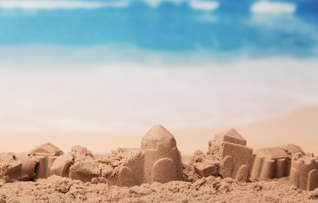 Battered sandcastles on the sunny ocean backgroundの写真素材