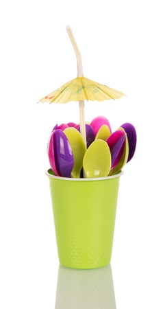 Green colored disposable cup with plastic spoon and an umbrella isolated on white background.の写真素材