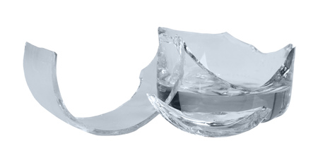 Fragments of broken glass close-up isolated on white background.