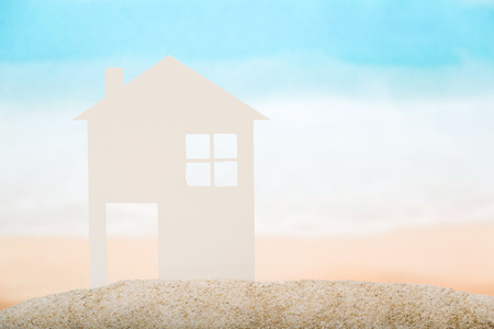 White paper house in the sand against the sea. Close-up.の写真素材