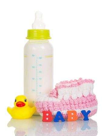 Bottle with milk mixture, booties, rubber duck, and the inscription BABY isolated on white background.の写真素材