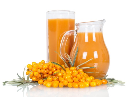Pitcher and a glass of juice from the berries of sea buckthorn isolated on white backgroundの写真素材