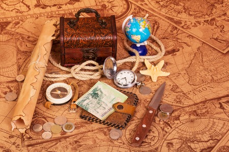 Accessories for the traveler: a compass, a pocket watch, a globe, a treasure trove of coins and a...