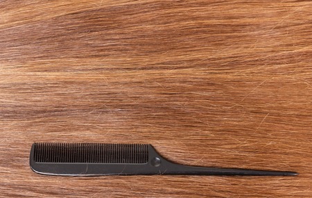 The long straight brown hair and comb. Background.の写真素材