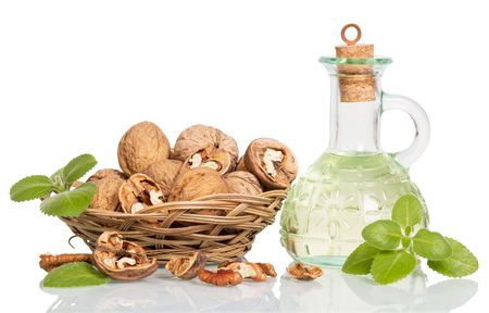 Wicker bowl with walnuts and oil bottle isolated on white background.の写真素材