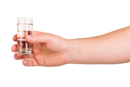 Man's hand keeps the glass vodka isolated on white background.の写真素材