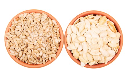 Two bowls of sunflower seeds and pumpkin isolated on white background. View from above.の写真素材