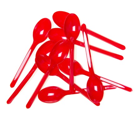 Red plastic spoon close-up isolated on white background.の写真素材