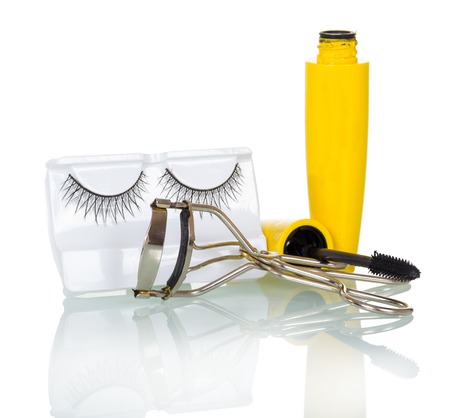 Black false eyelashes, mascara and hair curlers isolated on white background.の写真素材