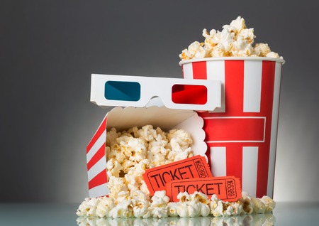 Movie tickets, popcorn and 3D glasses on a gray backgroundの写真素材