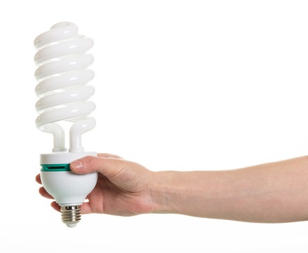 Hand holding spiral fluorescent lamp isolated on white background.
