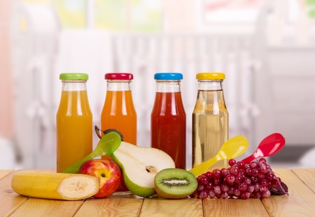 Fresh fruit and a bottle of juice on the background of these dishes.の写真素材