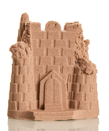 Slightly ruined tower of sand isolated on a white background.の写真素材