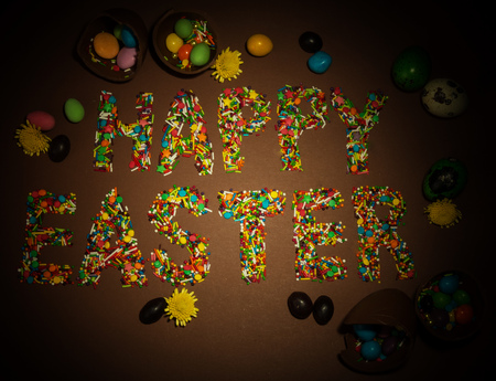 Inscription Happy Easter, built of colorful flouring for Easter, the broken chocolate eggs, dragees...