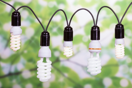 Garland of different fluorescent bulbs close-up on an abstract green background.