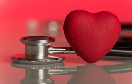 Phonendoscope and artificial heart on a pink backgroundの写真素材