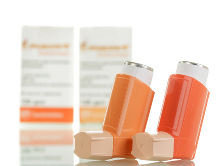 Two of the asthma inhaler and packaging of medicines isolated on white background.の写真素材