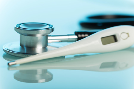Medical stethoscope and a thermometer on a blue background.の写真素材