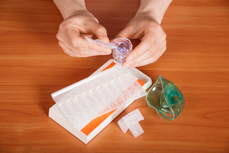 Female hands on the table prepare a medicine for inhalationの写真素材