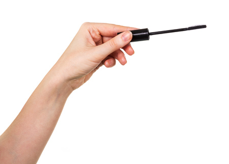 Cosmetic tassel dyeing mascara eyelashes in a female hand isolated on white background.の写真素材