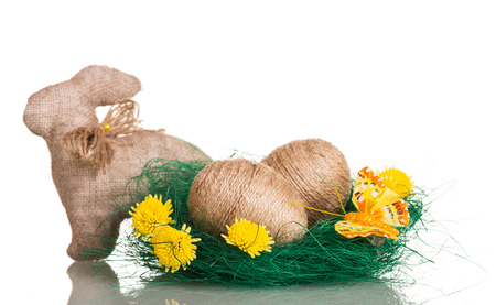 Easter eggs in the nest entwined with twine and easter bunny, flowers, isolated on white background.の写真素材