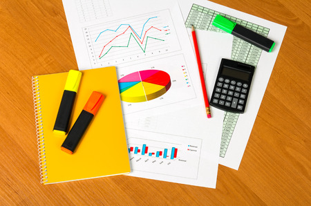Calculator, Notepad, markers, sheets of paper with accounts and charts, pencil on the desktop background.の写真素材