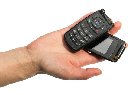 Female hand holding a broken mobile phone isolated on white background.の写真素材