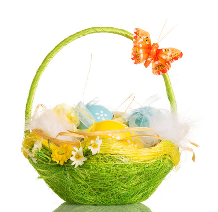 Basket with Easter eggs and a butterfly on the handle, isolated on a white background.の写真素材