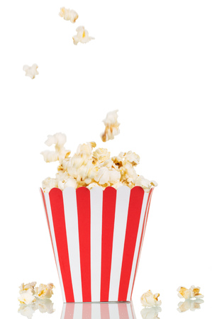A falling popcorn in a large square box and beside her, isolated on white background.の写真素材