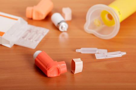 Inhalers aerosol, aerochamber box and medicine on the background of the table.の写真素材