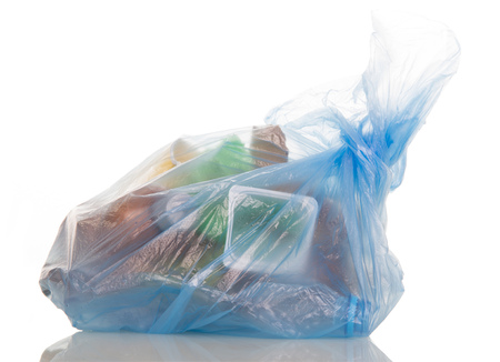 Blue plastic bag filled with household waste isolated on white background.の写真素材
