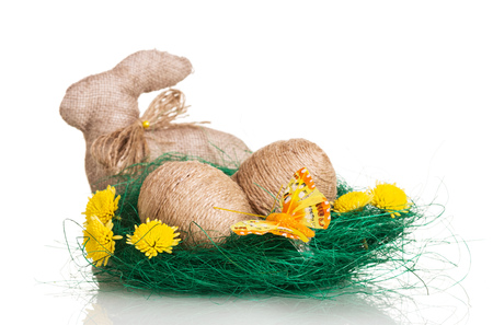 Easter eggs in the nest entwined with twine and the Easter bunny isolated on white background.の写真素材