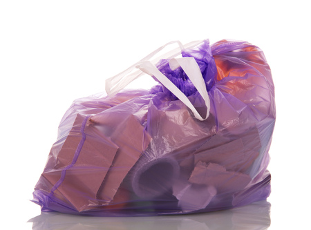 Closed lilac polyethylene bag with garbage isolated on white background.の写真素材