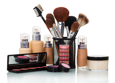 Cosmetic paint brushes, bottles with foundation, lip gloss, shadows, blush and cream jar isolated on white background.の写真素材