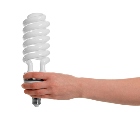In a female hand fluorescent light bulb close-up isolated on white background.の写真素材