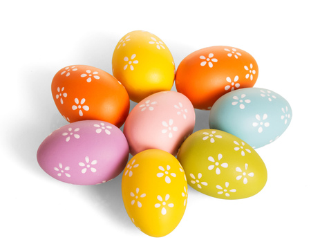 Easter colorful eggs, laid out in the shape of a flower, isolated on white background. View from above.の写真素材