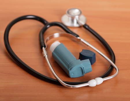 Medical stethoscope and inhaler on the background of the table.の写真素材