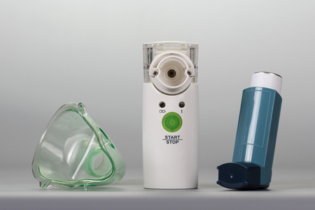 Ultrasonic nebulizer, an inhaler and a mask on a grey background.の写真素材