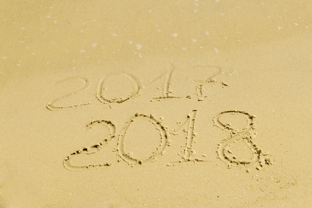 The inscription on the sand of 2017 is washed away with water, the new year 2018, a holiday on the warm coastの写真素材