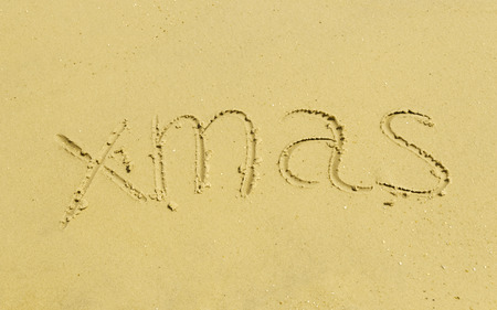 Xmas inscription on a golden sandy beach, a holiday at the seasideの写真素材