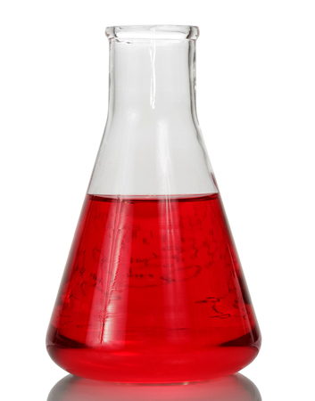 A chemical flask with a red liquid and a sheet of paper with formulas isolated on a white background.の写真素材