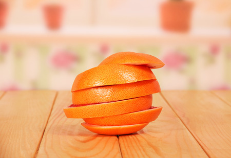Ripe grapefruit, cut into circles, folded as one closeup on the background of the kitchen.の写真素材