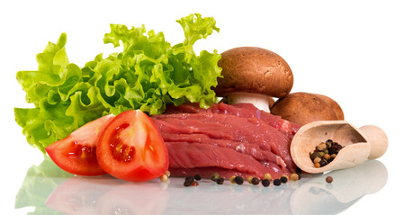 Pieces of raw beef, tomato pieces, mushrooms, lettuce, and scoop with pepper isolated on white background.の写真素材