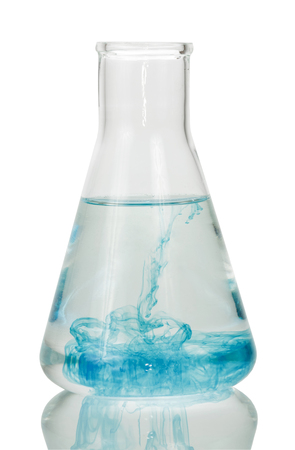 A chemical flask with a clear liquid and blue is isolated on a white background.の写真素材